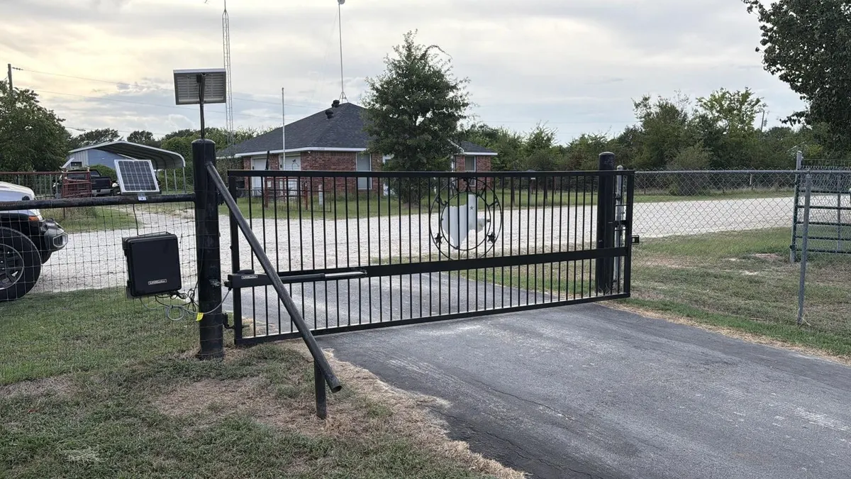 Wide view of the repaired swing gate and solar setup.